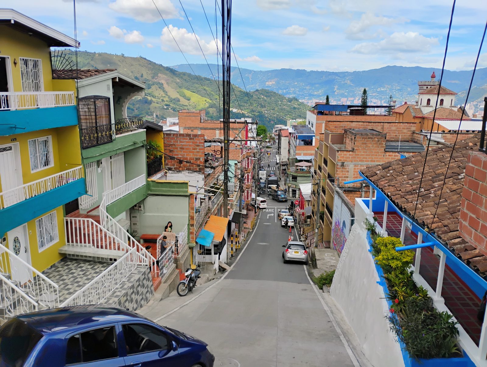 Calle en pendiente de San Antonio de Prado con vista a las monta&ntilde;as del Valle de Aburr&aacute;.
