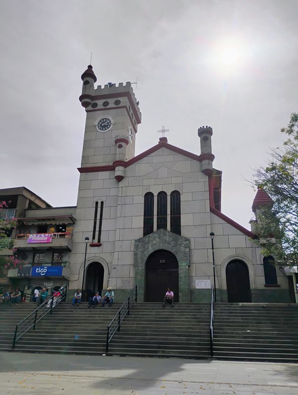 Fachada del templo con su torre almenada y reloj.